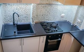 Дизайн маленькой кухни 7 кв.м с мозаичным фартуком и черной столешницей-подоконником