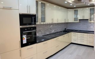 Современная бежевая глянцевая кухня со встроенным холодильником